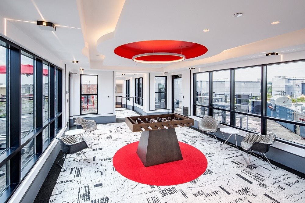 a conference room with a table and chairs and a red rug